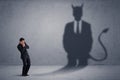 Business man looking at his own devil demon shadow concept Royalty Free Stock Photo