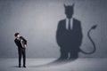 Business man looking at his own devil demon shadow concept Royalty Free Stock Photo