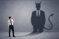 Business man looking at his own devil demon shadow concept Royalty Free Stock Photo