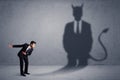 Business man looking at his own devil demon shadow concept Royalty Free Stock Photo