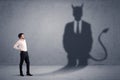 Business man looking at his own devil demon shadow concept Royalty Free Stock Photo