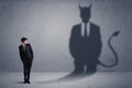 Business man looking at his own devil demon shadow concept Royalty Free Stock Photo