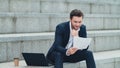 Business man looking at papers on street. Executive thinking about graphs Royalty Free Stock Photo