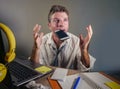 Business man in lose necktie messy and depressed working at laptop computer in business office problem suffering stress biting mob Royalty Free Stock Photo