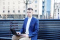 Business man. A man with a book and a laptop. The guy speaks through the phone on the street. The guy in the glasses makes notes i Royalty Free Stock Photo