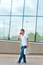 Business man with metal case and mobile phone in front of modern business building Royalty Free Stock Photo