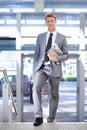 Business man, newspaper and travel at airport for portrait with walking, suitcase and commute on trip. Professional Royalty Free Stock Photo