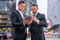 Business man in night Ney York. The two business teams men team using tablet laptop outdoor. Businessmen looking tablet Royalty Free Stock Photo