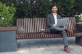 Business man office worker working on laptop in urban park background and looking away Royalty Free Stock Photo