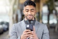 Business man, phone and city of a professional with headphones watching a video. Urban, smile and Indian male person Royalty Free Stock Photo