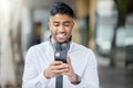 Business man, phone text and city of a professional with headphones watching a video. Urban, smile and Indian male Royalty Free Stock Photo