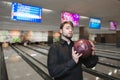 Business man playing bowling. Portrait of a man with a ball in his hands against the background of tracks for bowling. Royalty Free Stock Photo