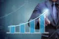 Business man point hand on the top of arrow graph with high rate of growth. The success and growing growth graph in the company or Royalty Free Stock Photo