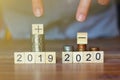 Business man pointing his fingers to stack of coins and plus sign,minus sign world economic.business concept