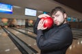 A business man posing on a camera with bowling ball in his hands. A man with a beard plays a bowling club. Royalty Free Stock Photo