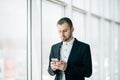 Business man prepare phone flight from app with luggage in building airport terminal. Business trip Royalty Free Stock Photo