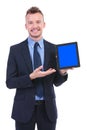 Business man presents a tablet with a smile Royalty Free Stock Photo