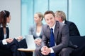 Business man with professionals in background. Portrait of relaxed young business man with professionals discussing in
