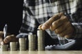 Business man putting a coin on coins stack saving bank and account for his money all in finance accounting concept Royalty Free Stock Photo