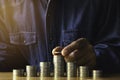 Business man putting  a coin on coins stack saving bank and account for his money all in finance accounting concept Royalty Free Stock Photo