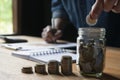 Business man putting coin in glass bottle saving bank and account for his money all in finance accounting concept. Royalty Free Stock Photo