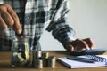 Business man putting coin in glass bottle saving bank and account for his money all in finance accounting concept. Royalty Free Stock Photo