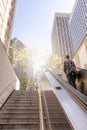 Business man raising stairs to reach the city