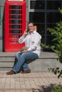 Business man on red classic English telephone box Royalty Free Stock Photo