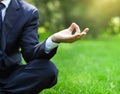 Business man relax in a park in the lotus position