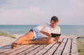 Business man relaxing using tablet computer at sea beach Royalty Free Stock Photo