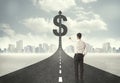 Business man on road heading toward a dollar sign Royalty Free Stock Photo