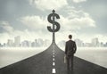 Business man on road heading toward a dollar sign Royalty Free Stock Photo