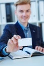 Business man`s hand holding blank calling card. Male hand showing white visiting card in camera closeup. Partners Royalty Free Stock Photo