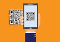 Business man`s hand holding smartphone scanning QR code on orange background