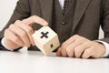 a business man& x27;s hand holds a wooden cube block to change minus sign to plus sign on white background. positive