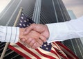 Business man shaking their hands against american flag and skyscraper Royalty Free Stock Photo