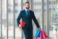 Business man shopping in a shopping center. Happy businessman in suit holding paperbags. Shopaholic man walking on Royalty Free Stock Photo