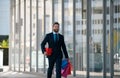 Business man shopping in a shopping center. Happy businessman in suit holding paperbags. Shopaholic man walking on Royalty Free Stock Photo