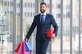 Business man shopping in a shopping center. Happy businessman in suit holding paperbags. Shopaholic man walking on Royalty Free Stock Photo