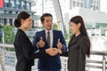 Business man show thumb up and two business woman shaking hands for demonstrating their agreement to sign agreement or contract Royalty Free Stock Photo