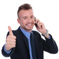 Business man shows thumb up while on phone Royalty Free Stock Photo