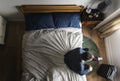 Business man sitting on the bed using his cellphone Royalty Free Stock Photo