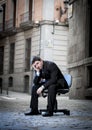 Business Man sitting on Office Chair on Street in stress Royalty Free Stock Photo