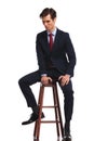 Business man sitting on stool and looks away to side Royalty Free Stock Photo