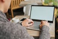 business man sitting at a table in a cafe with a laptop using a smartphone