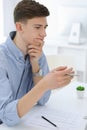 Business man sitting and working with computer and calculator in white office. Student guy studying at home or young Royalty Free Stock Photo