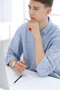 Business man sitting and working with computer and calculator in white office. Student guy studying at home or young Royalty Free Stock Photo