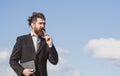 Business man with sky. Business man is thinking about something with pencil. Business dreams. Thoughtful young man in Royalty Free Stock Photo