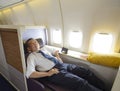 Business man sleeping at the first class of airplane in comfortable single seat