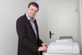 Business man smiling near a copy machine Royalty Free Stock Photo